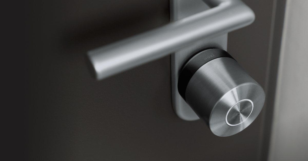 La Smart Lock Ultra con anillo negro, instalada en una puerta negra con herrajes plateados.