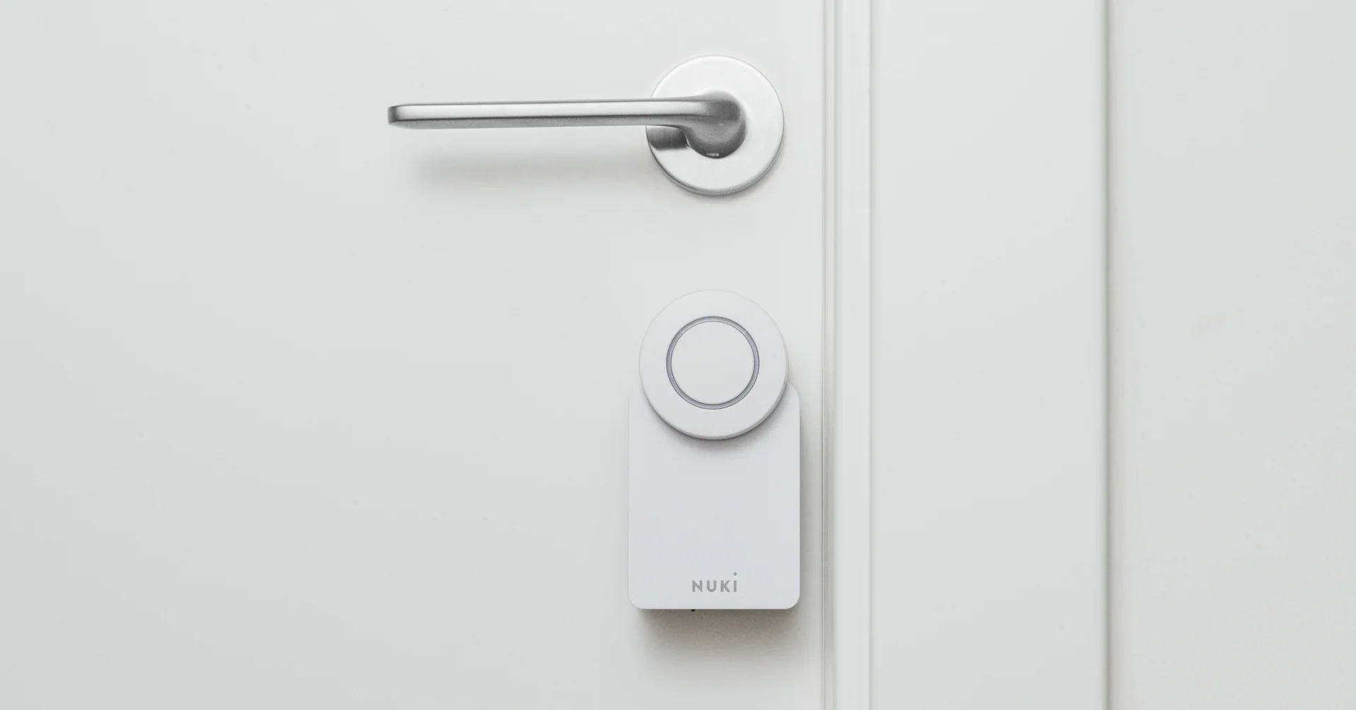 A Smart Lock Go is mounted on a white door with silver hardware. 