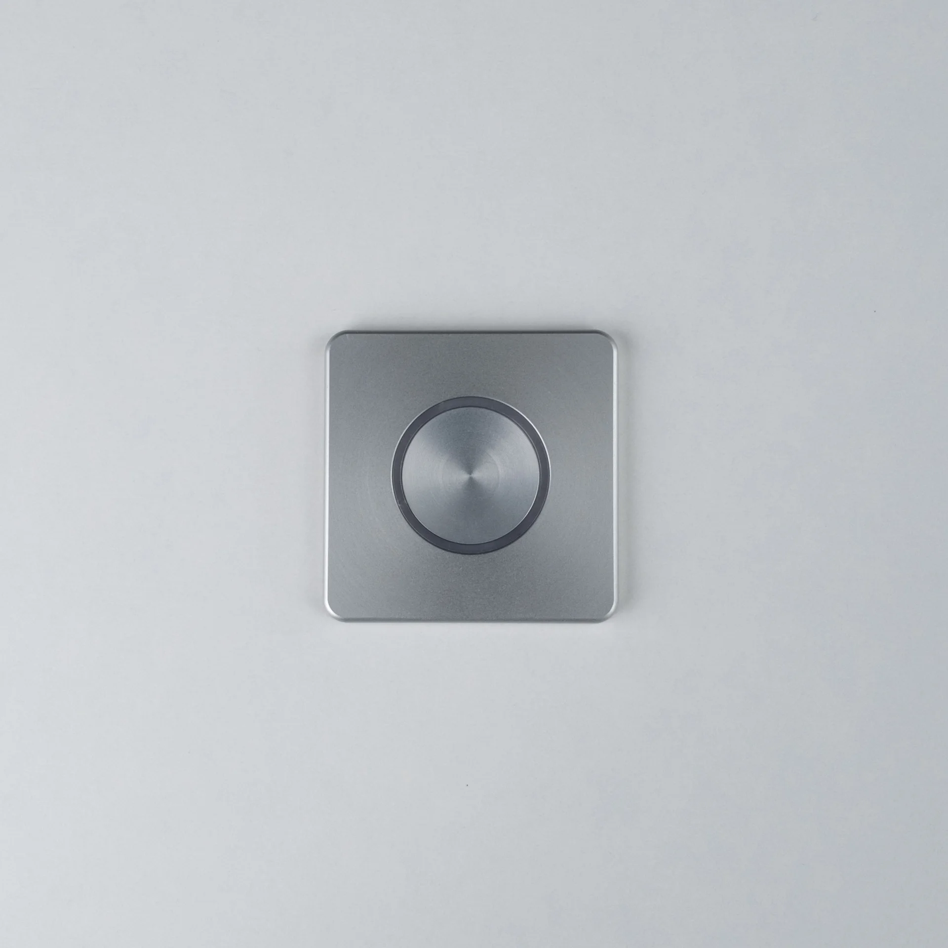 Silver Nuki Button, square, integrated in a white door – turns a mechanical lock into a smart door.