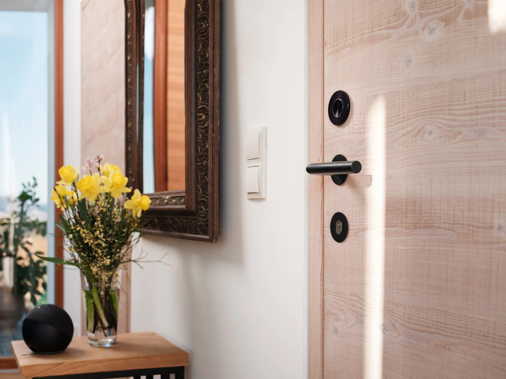 Nuki Smart Door with black fittings on wooden door in stylish entryway.