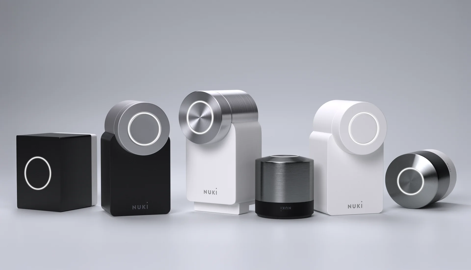 The Nuki portfolio lined up in front of a grey background. The Nuki Bridge and all Smart Locks.