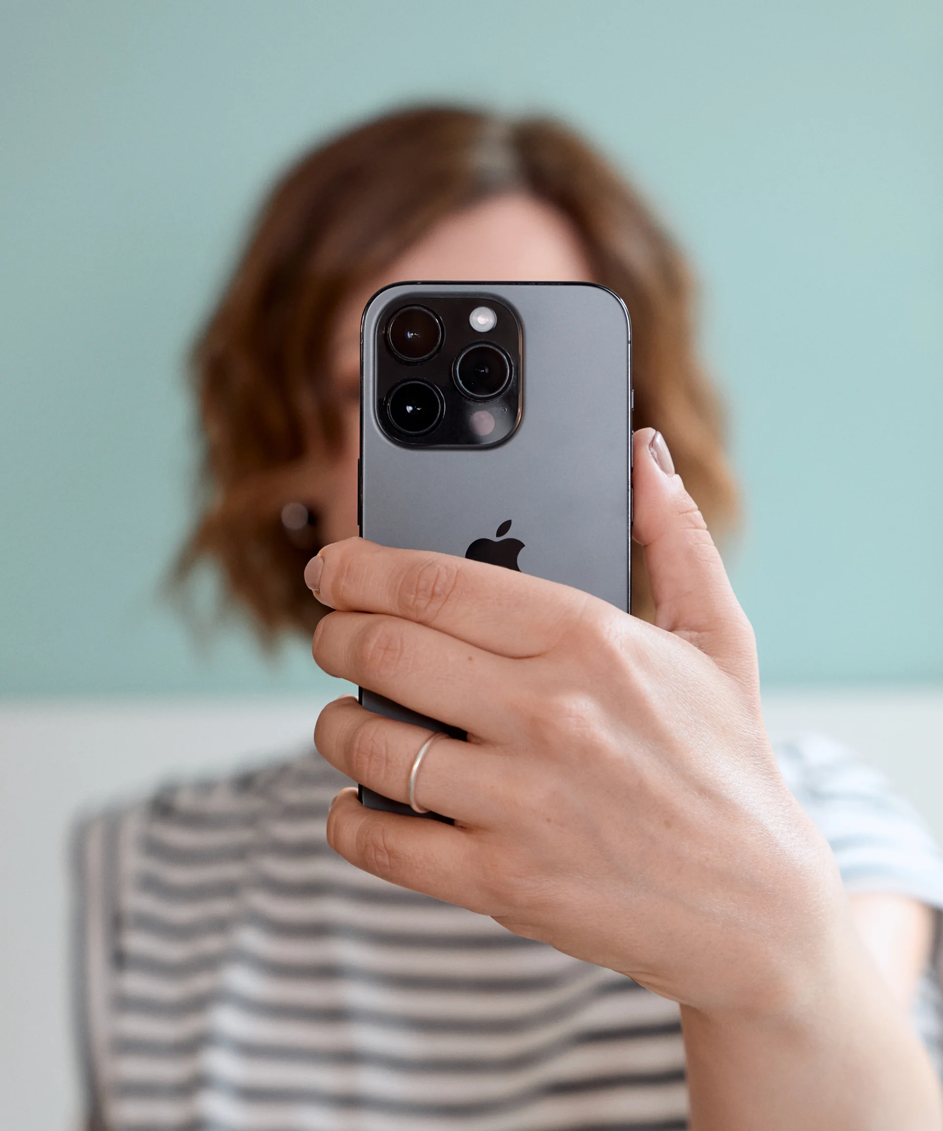 Woman holding the backside of her smartphone into the camera