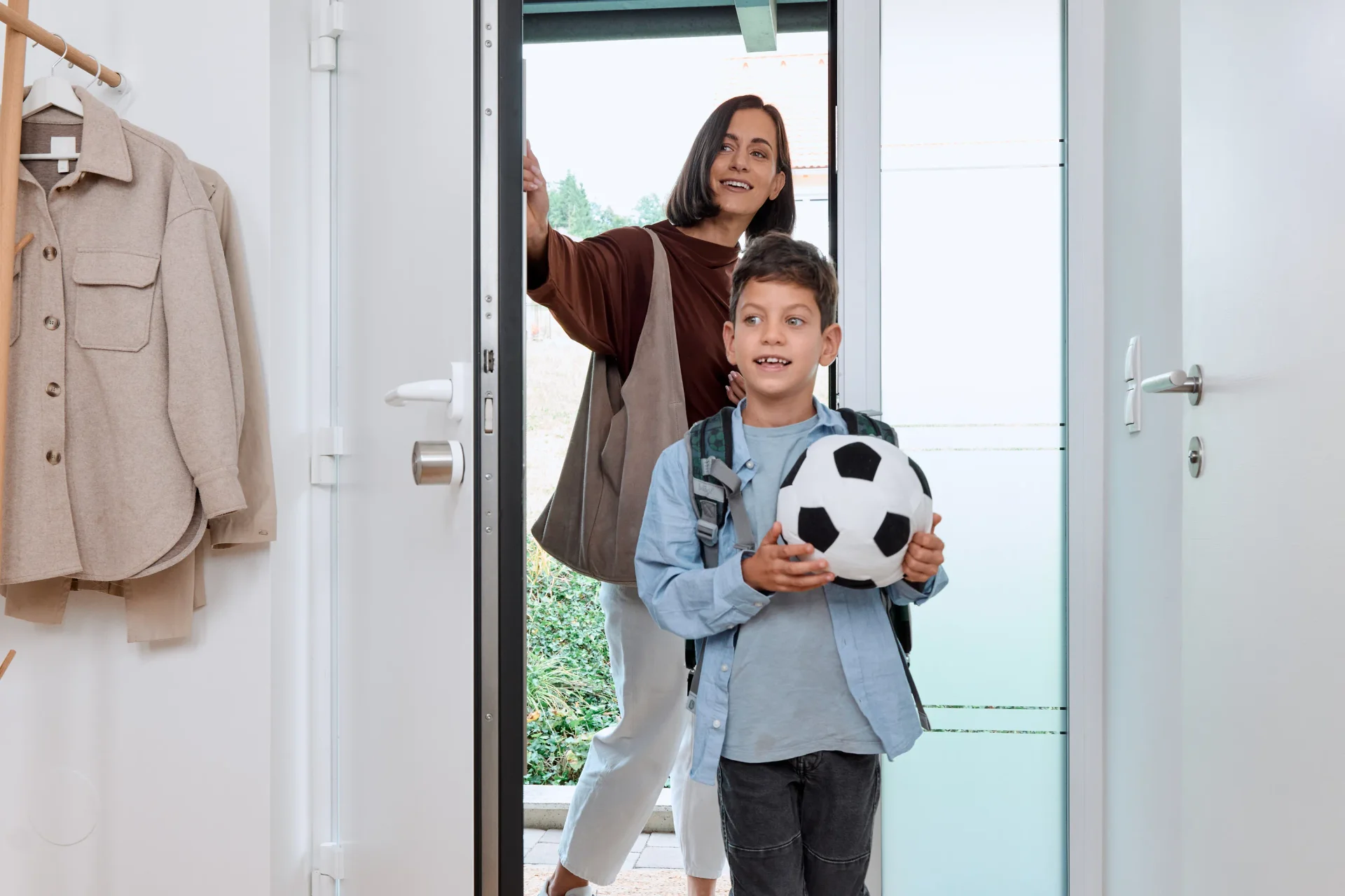 Happy mom and happy son with football coming home.