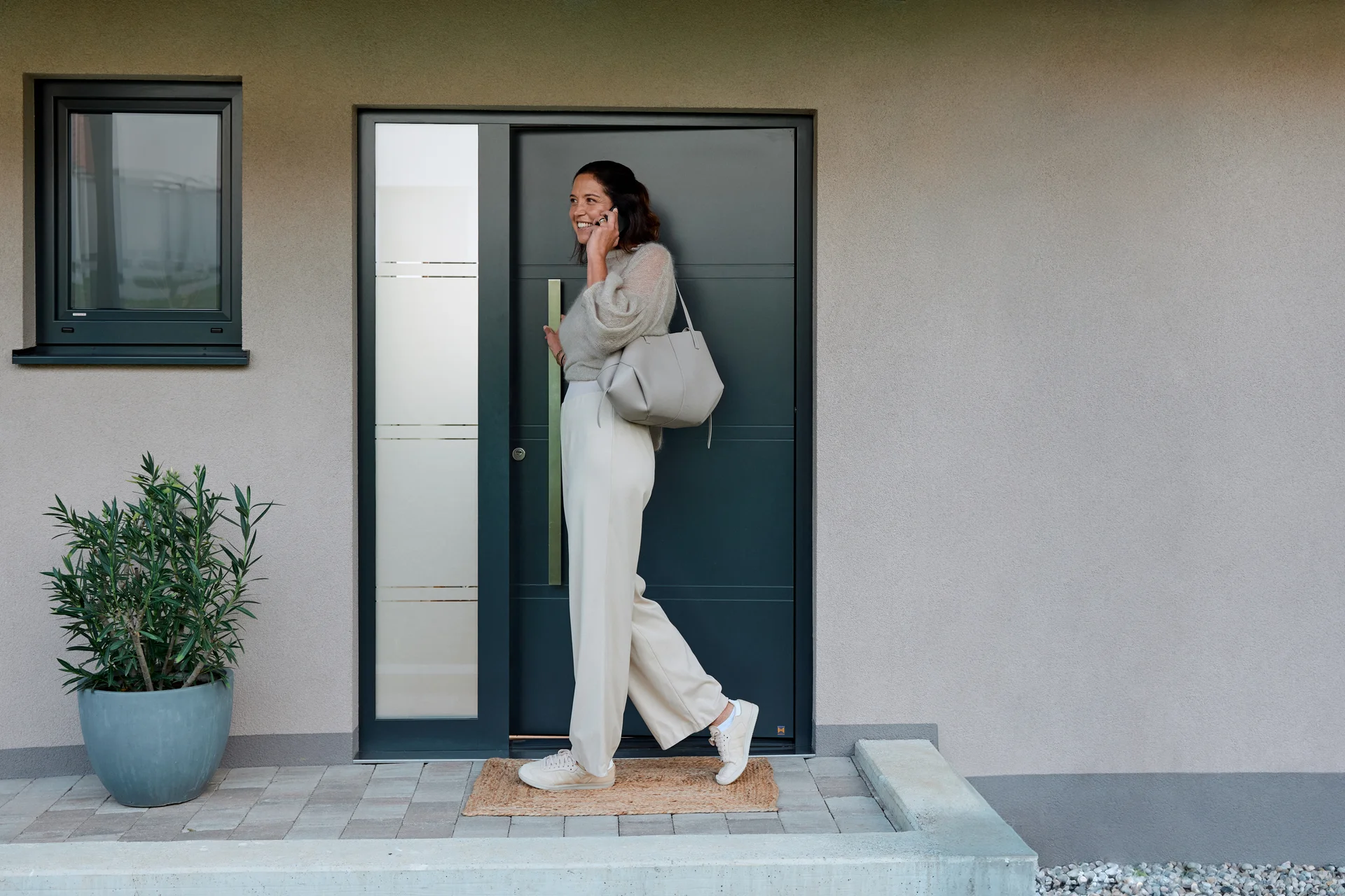 Woman entering her home thanks to Auto Unlock while speaking on the phone.